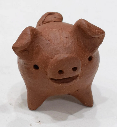 An image of a chanchito, a round, three-legged pig sculpture with floppy ears and holes for eyes.